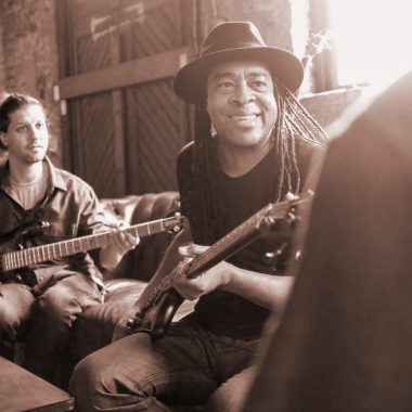 two seated men holding Spector basses