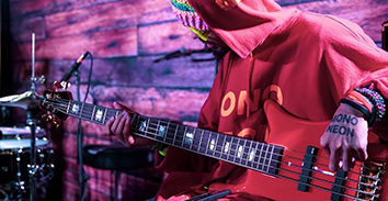 musician in sweatshirt playing electric bass