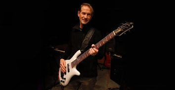 Graham Maby playing electric bass in concert